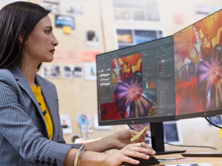 Una mujer trabajo con dos monitores.