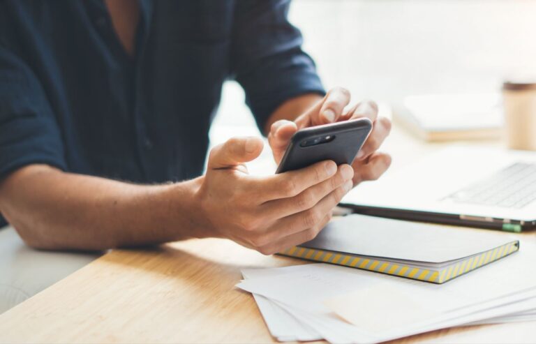 Un empleado trabaja con un smartphone (Adobe)